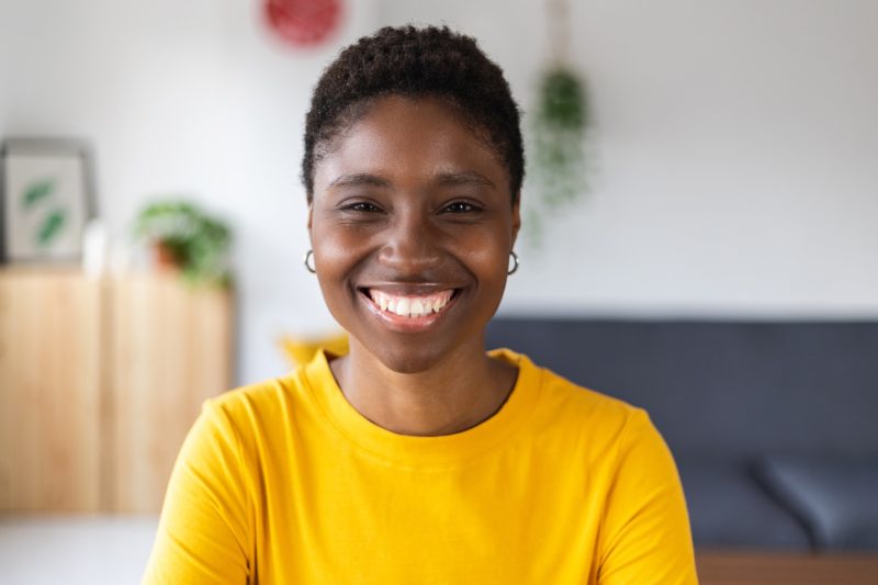 portrait-screen-view-of-smiling-millennial-african-woman-on-video-call-at-home-e1655156238810.jpg