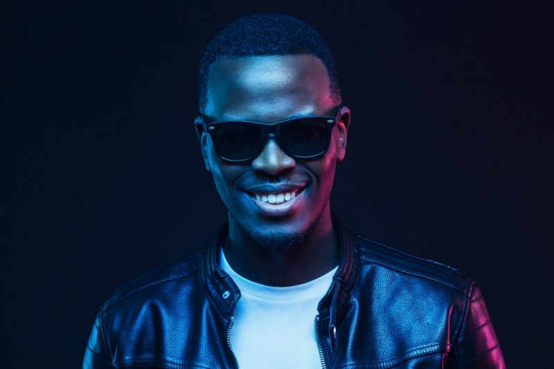 studio-portrait-of-smiling-african-american-male-model-wearing-trendy-sunglasses-and-leather-jacket-e1655156746850.jpg